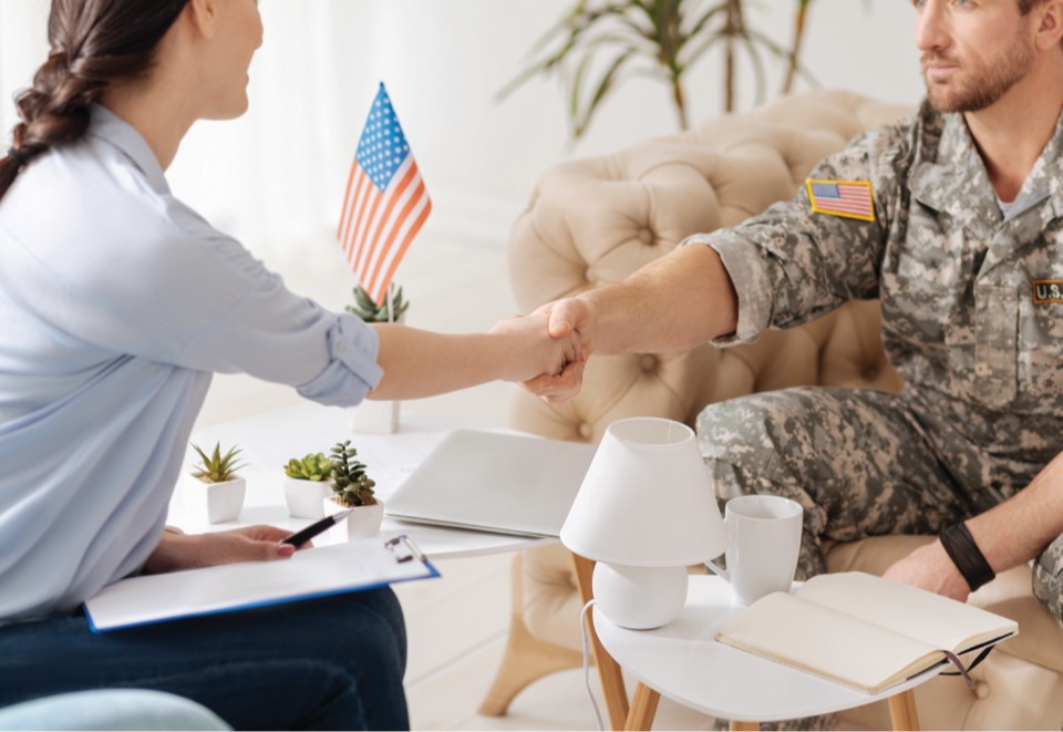 Therapist shaking hands with a military service member with the words cognitive behavioral therapy strategies