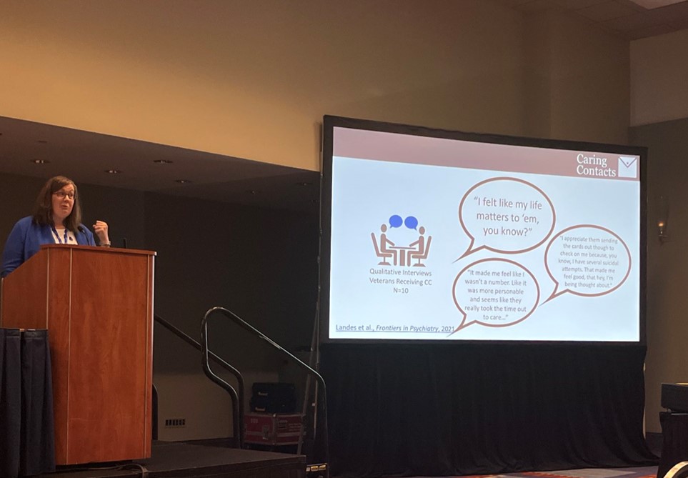 Dr. Sara Landes standing at a podium