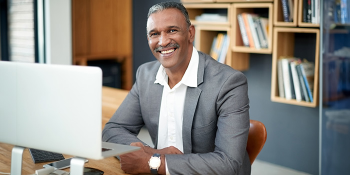 Veteran benefit counselor smiling behind a computer