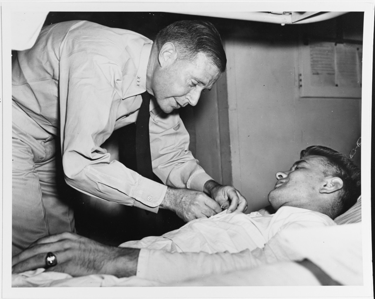 Commander, Central Pacific Force Presents the Purple Heart to Corporal John K. Galuszka, USMC, on board a hospital ship at Pearl Harbor, 17 December 1943. Corporal Galuszka had been wounded during the Gilberts Operation. Official U.S. Navy Photograph, now in the collections of the U.S. National Archives.